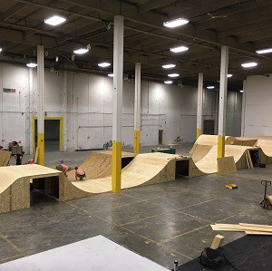 Workers build ramps inside the B-Line Indoor Bike Park BMX centre, which will open in August in Calgary. It's part of a trend toward more indoor sports and recreation facilities.